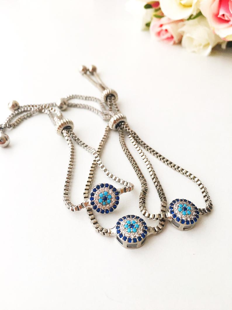 A beautifully crafted Evil Eye Bracelet Set featuring adjustable designs with clover and elephant charms in gold and silver.