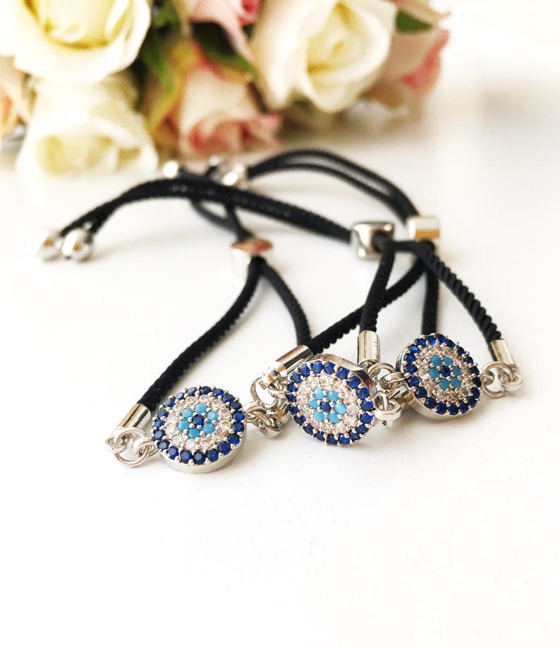 A beautifully crafted Evil Eye Bracelet Set featuring adjustable designs with clover and elephant charms in gold and silver.