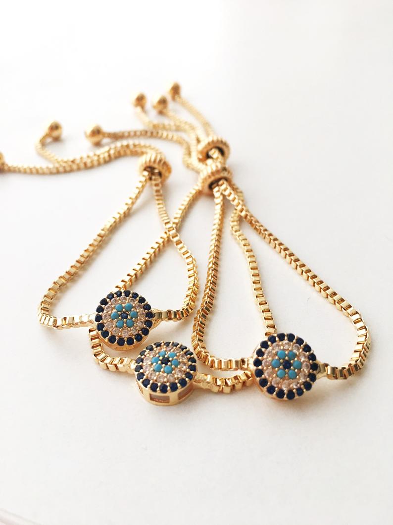 A beautifully crafted Evil Eye Bracelet Set featuring adjustable designs with clover and elephant charms in gold and silver.