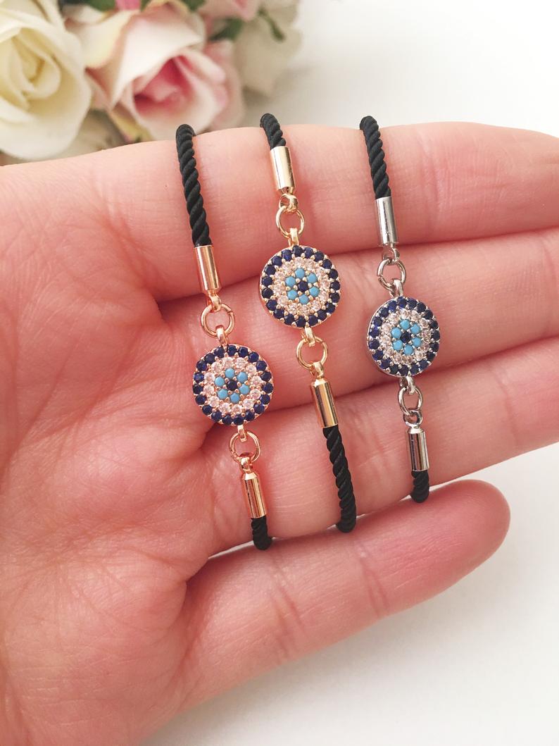 A beautifully crafted Evil Eye Bracelet Set featuring adjustable designs with clover and elephant charms in gold and silver.