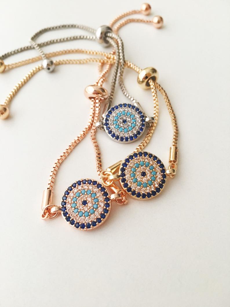 A beautifully crafted Evil Eye Bracelet Set featuring adjustable designs with clover and elephant charms in gold and silver.