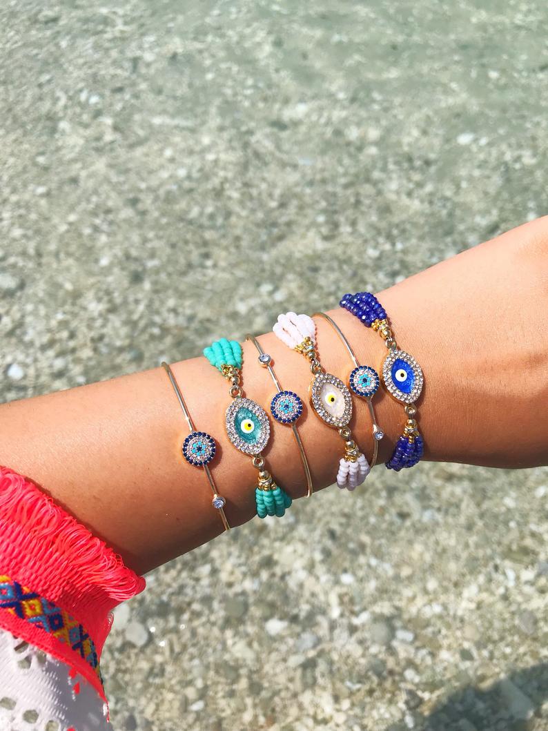 A beautiful Evil Eye Bracelet Set featuring gold bangle and colorful beaded designs, showcasing the evil eye symbol for protection.