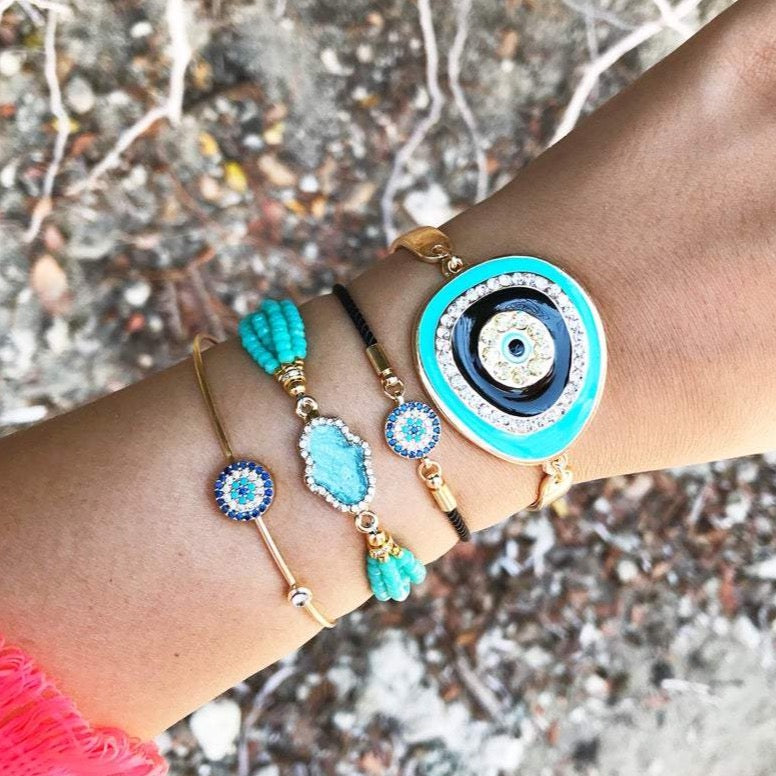 Evil Eye Bracelet Set featuring gold bangles and turquoise hamsa charm, showcasing adjustable design and handmade craftsmanship.