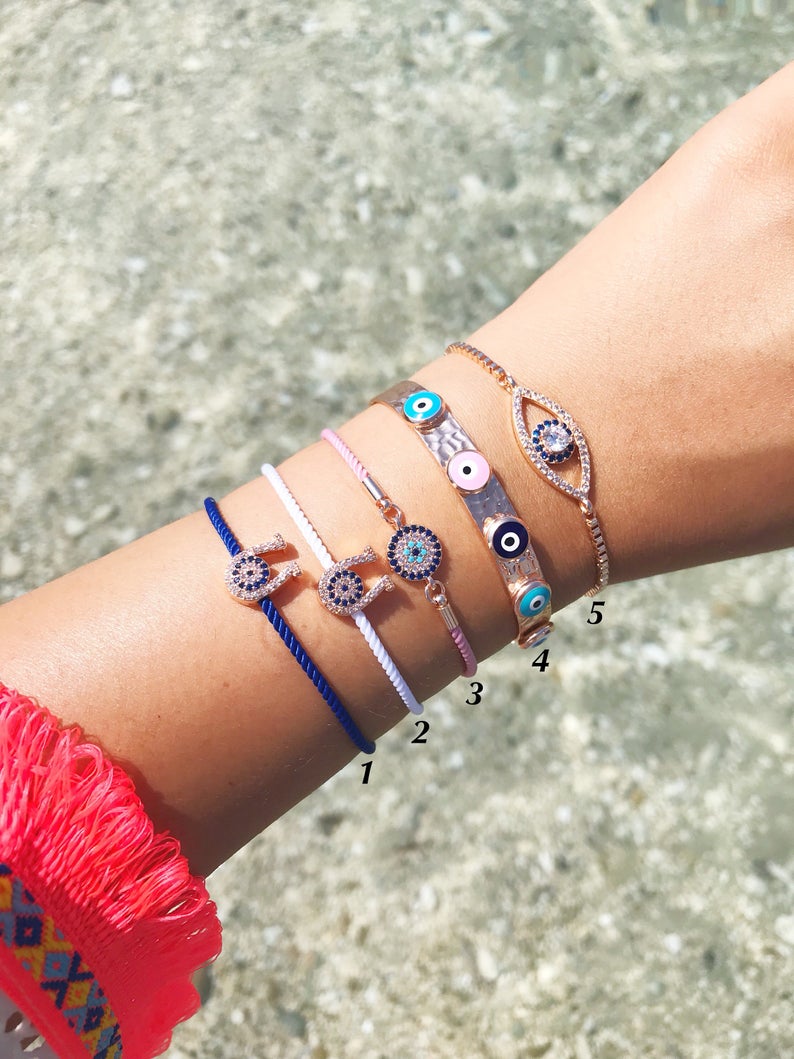 A collection of five unique evil eye bracelets featuring horseshoe charms and adjustable designs, crafted from tarnish-resistant stainless steel.