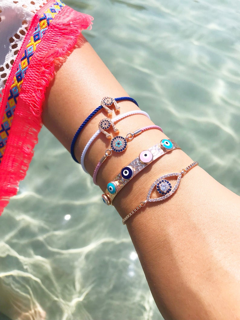 A collection of five unique evil eye bracelets featuring horseshoe charms and adjustable designs, crafted from tarnish-resistant stainless steel.