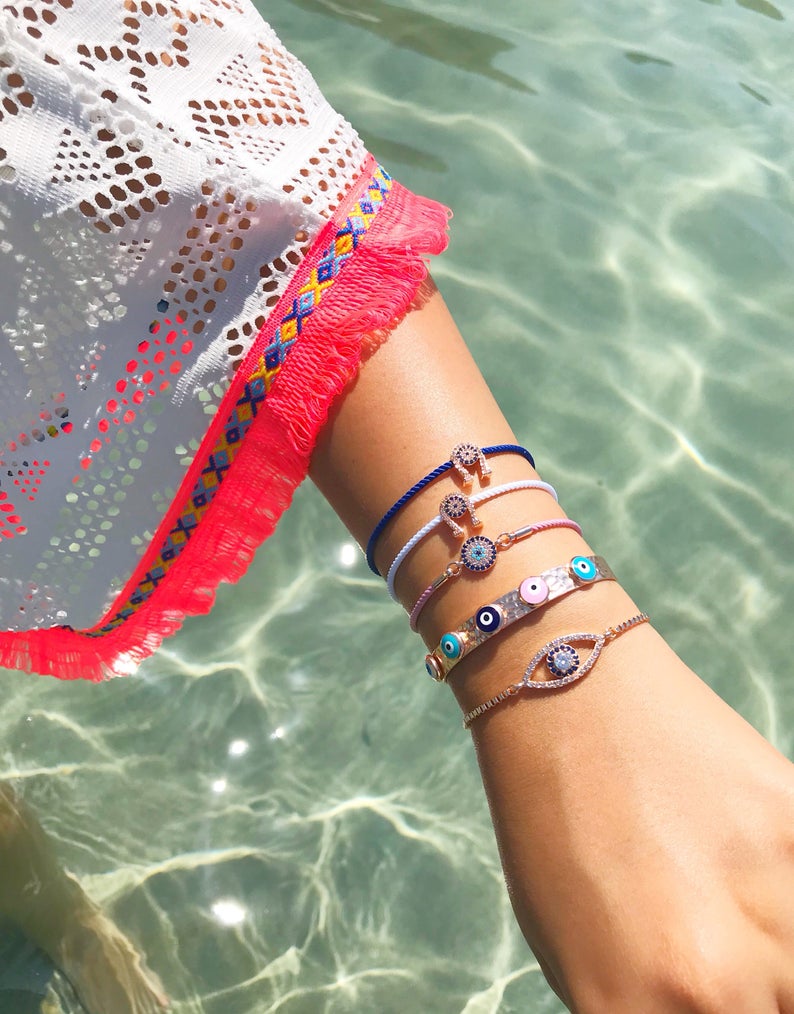 A collection of five unique evil eye bracelets featuring horseshoe charms and adjustable designs, crafted from tarnish-resistant stainless steel.