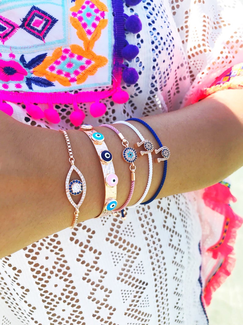 A collection of five unique evil eye bracelets featuring horseshoe charms and adjustable designs, crafted from tarnish-resistant stainless steel.