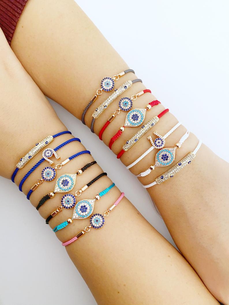 A beautiful adjustable evil eye bracelet featuring zircon charms, crafted from tarnish-resistant stainless steel, showcasing its unique design.