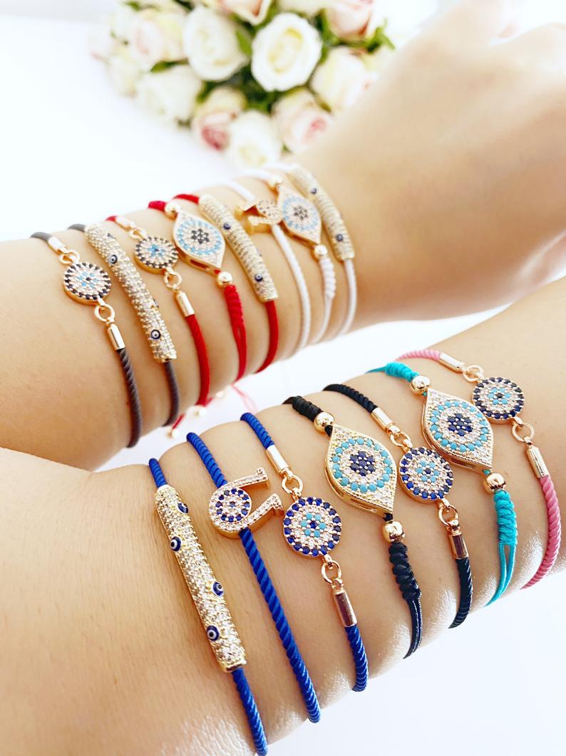 A beautiful adjustable evil eye bracelet featuring zircon charms, crafted from tarnish-resistant stainless steel, showcasing its unique design.