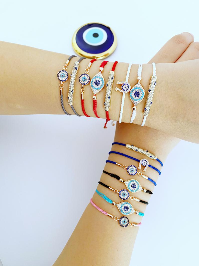 A beautiful adjustable evil eye bracelet featuring zircon charms, crafted from tarnish-resistant stainless steel, showcasing its unique design.