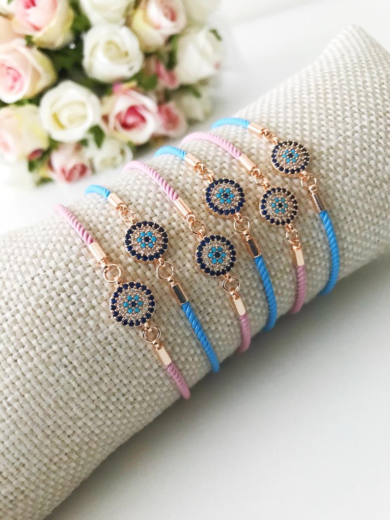 Adjustable Evil Eye Bracelet featuring pink and blue strings with a zircon evil eye bead, showcasing its handmade craftsmanship.