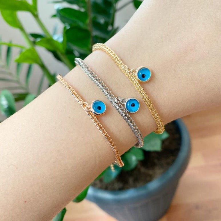Evil Eye Chain Bracelet featuring a blue evil eye bead on a rose gold Byzantine chain, showcasing intricate design and elegance.