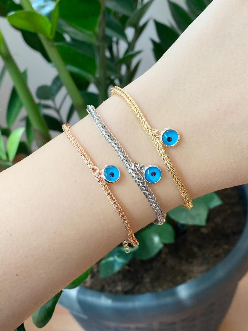 Evil Eye Chain Bracelet featuring a blue evil eye bead on a rose gold Byzantine chain, showcasing intricate design and elegance.