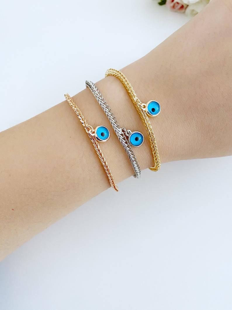Evil Eye Chain Bracelet featuring a blue evil eye bead on a rose gold Byzantine chain, showcasing intricate design and elegance.