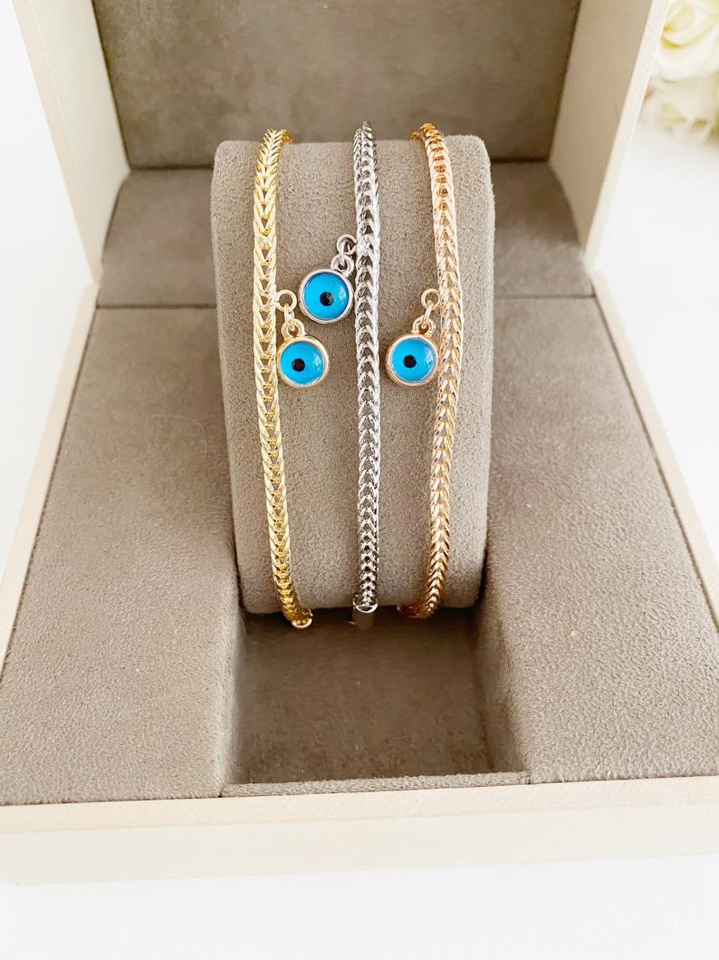 Evil Eye Chain Bracelet featuring a blue evil eye bead on a rose gold Byzantine chain, showcasing intricate design and elegance.