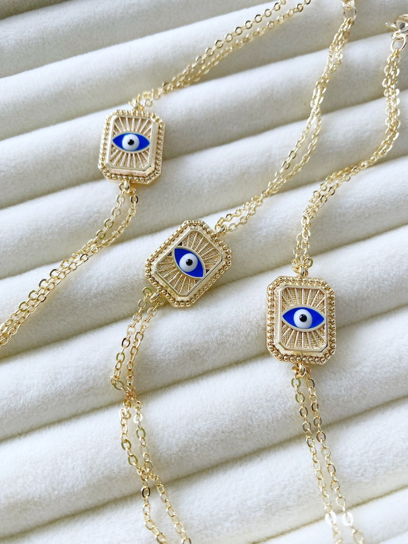 Elegant blue evil eye chain bracelet with double chain design, featuring handmade blue beads for protection and style.