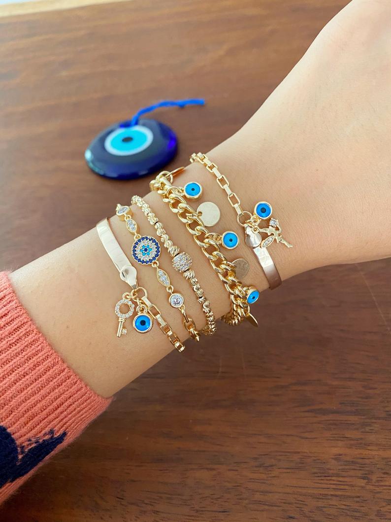 Gold Evil Eye Chain Bracelet featuring a blue charm, handmade with adjustable stainless steel for durability and style.