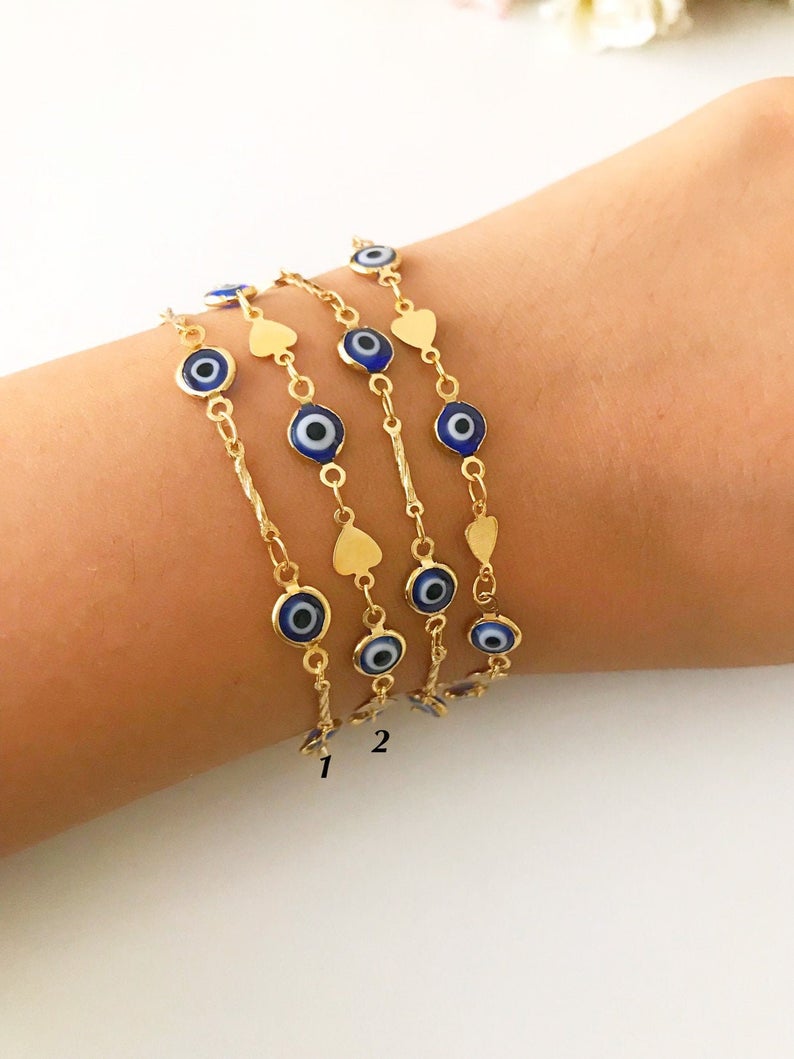 Elegant Evil Eye Chain Bracelet featuring blue evil eye beads on a gold link chain, showcasing its handmade craftsmanship and protective charm.