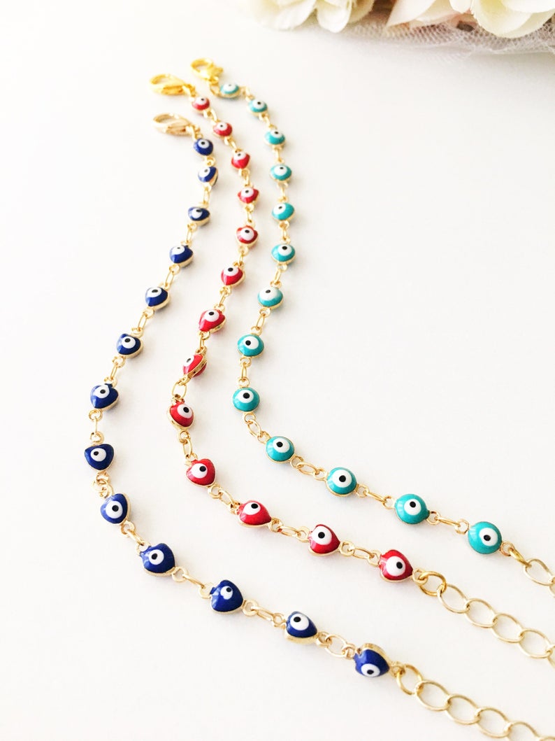 A beautiful Evil Eye Chain Bracelet featuring a gold link chain and tiny blue evil eye beads, perfect for minimalist jewelry lovers.