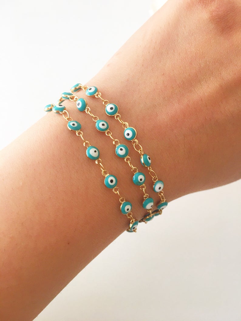 A beautiful Evil Eye Chain Bracelet featuring a gold link chain and tiny blue evil eye beads, perfect for minimalist jewelry lovers.