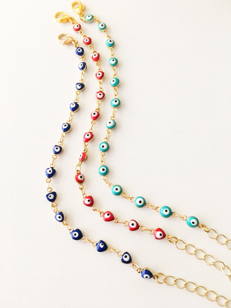 A beautiful Evil Eye Chain Bracelet featuring a gold link chain and tiny blue evil eye beads, perfect for minimalist jewelry lovers.