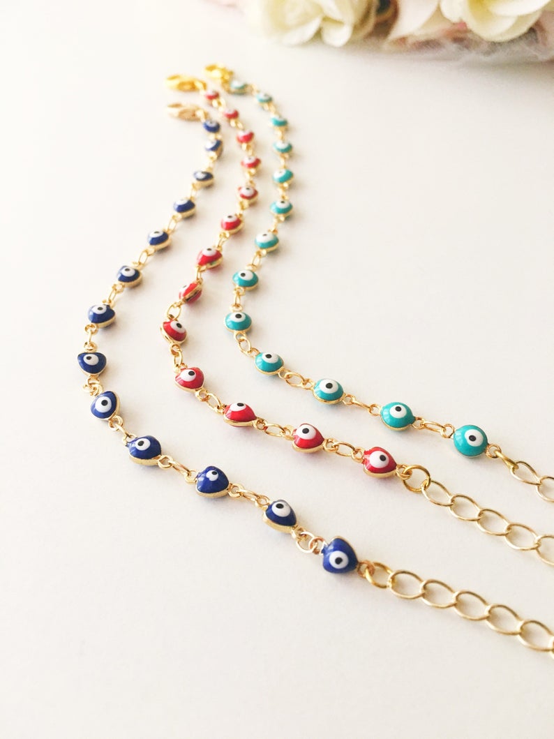 A beautiful Evil Eye Chain Bracelet featuring a gold link chain and tiny blue evil eye beads, perfect for minimalist jewelry lovers.