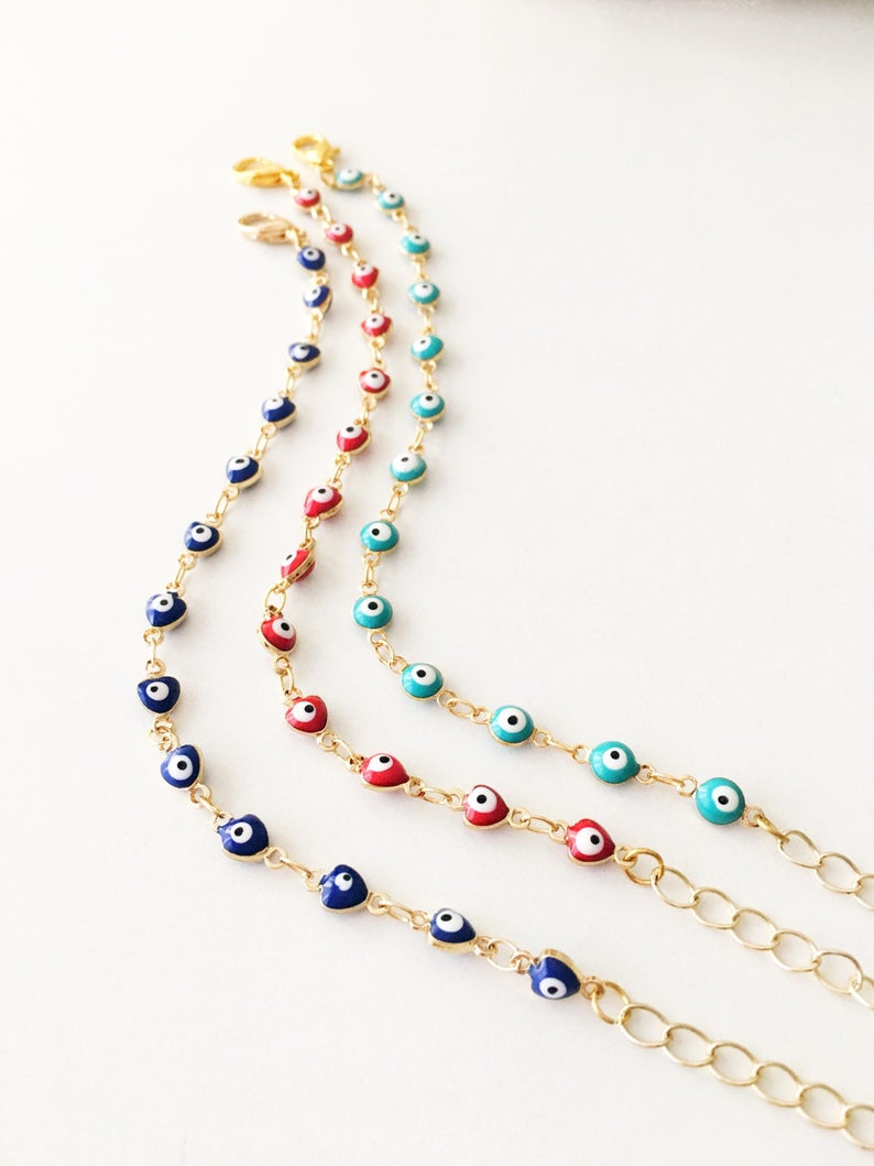 A beautiful Evil Eye Chain Bracelet featuring a gold link chain and tiny blue evil eye beads, perfect for minimalist jewelry lovers.