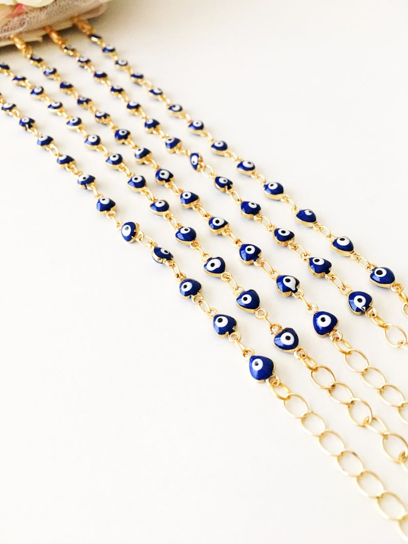 A beautiful Evil Eye Chain Bracelet featuring a gold link chain and tiny blue evil eye beads, perfect for minimalist jewelry lovers.