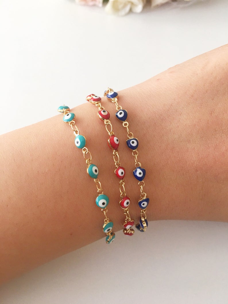 A beautiful Evil Eye Chain Bracelet featuring a gold link chain and tiny blue evil eye beads, perfect for minimalist jewelry lovers.