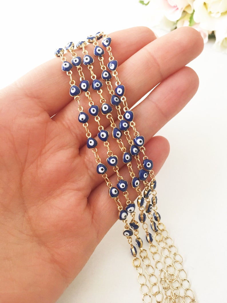 A beautiful Evil Eye Chain Bracelet featuring a gold link chain and tiny blue evil eye beads, perfect for minimalist jewelry lovers.