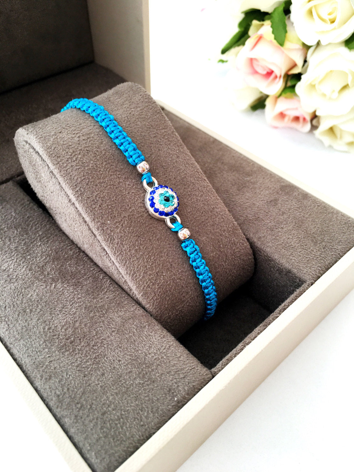 Handmade Evil Eye Charm Bracelet featuring a blue string and zirconia charm, adjustable black macramé design.