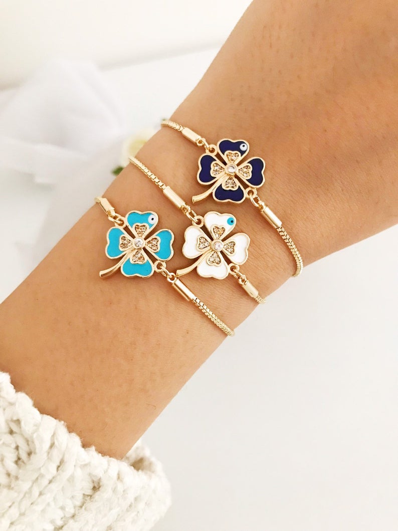 Handmade adjustable gold Evil Eye Clover Bracelet featuring a clover charm and tiny evil eye, available in multiple colors.