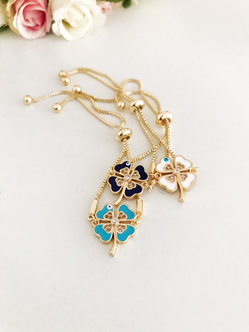 Handmade adjustable gold Evil Eye Clover Bracelet featuring a clover charm and tiny evil eye, available in multiple colors.