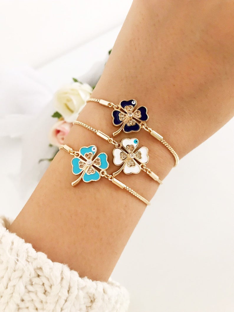Handmade adjustable gold Evil Eye Clover Bracelet featuring a clover charm and tiny evil eye, available in multiple colors.