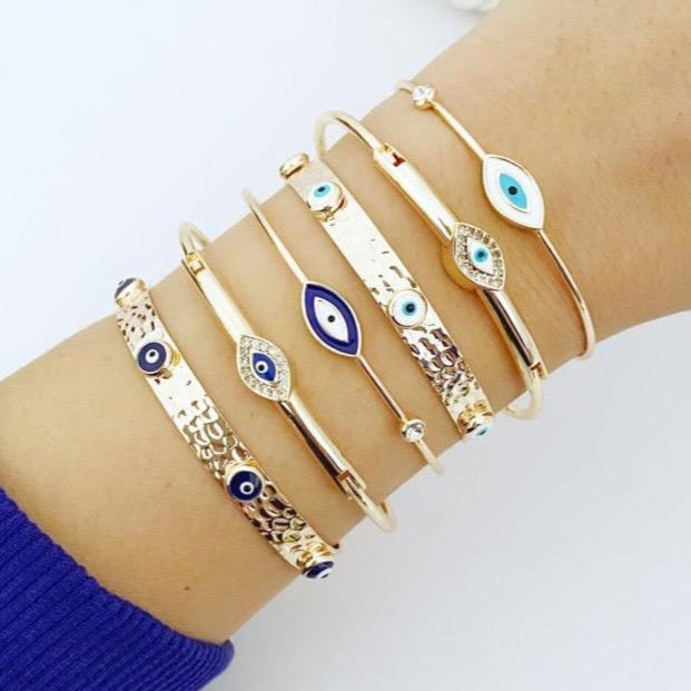 Gold Evil Eye Cuff Bracelet featuring a movable oval charm and adjustable stainless steel bangle, showcasing intricate handmade craftsmanship.