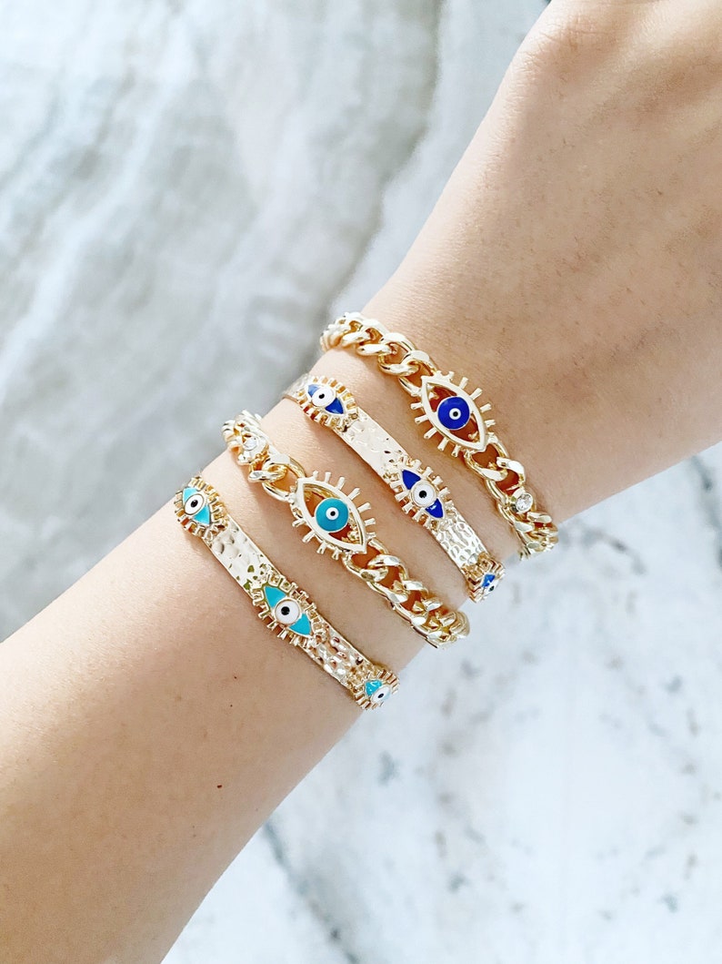 Gold Evil Eye Cuff Bracelet featuring a movable blue evil eye charm, adjustable design, and tarnish resistant stainless steel material.