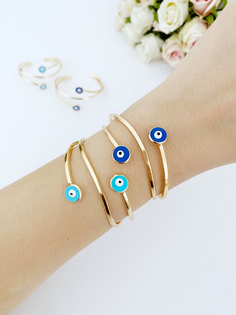 Gold Evil Eye Cuff Bracelet featuring a movable oval charm and adjustable stainless steel design, perfect for stylish protection.