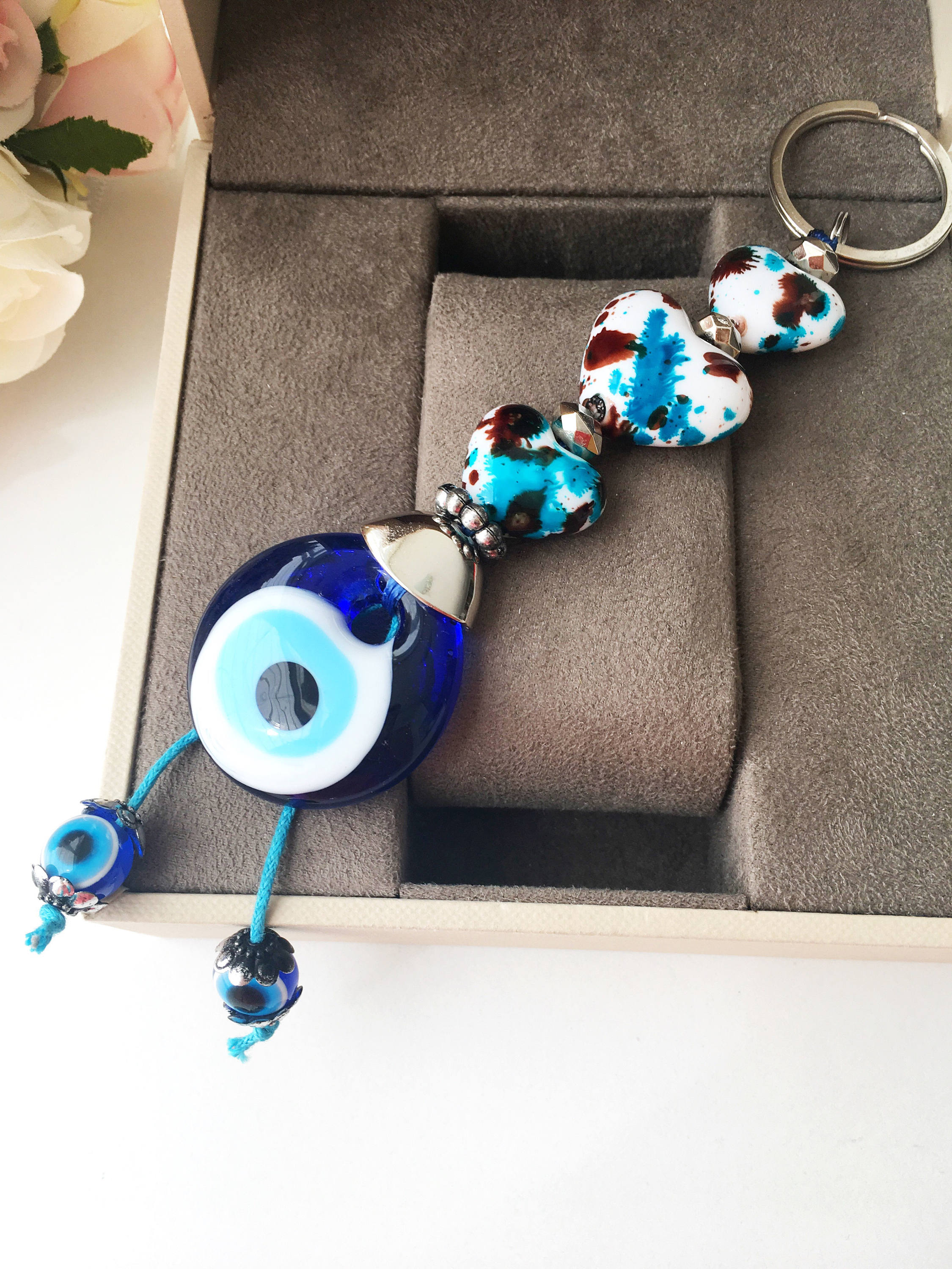 Evil eye key chain featuring a ceramic heart charm, symbolizing protection and good luck, perfect for keys or bags.