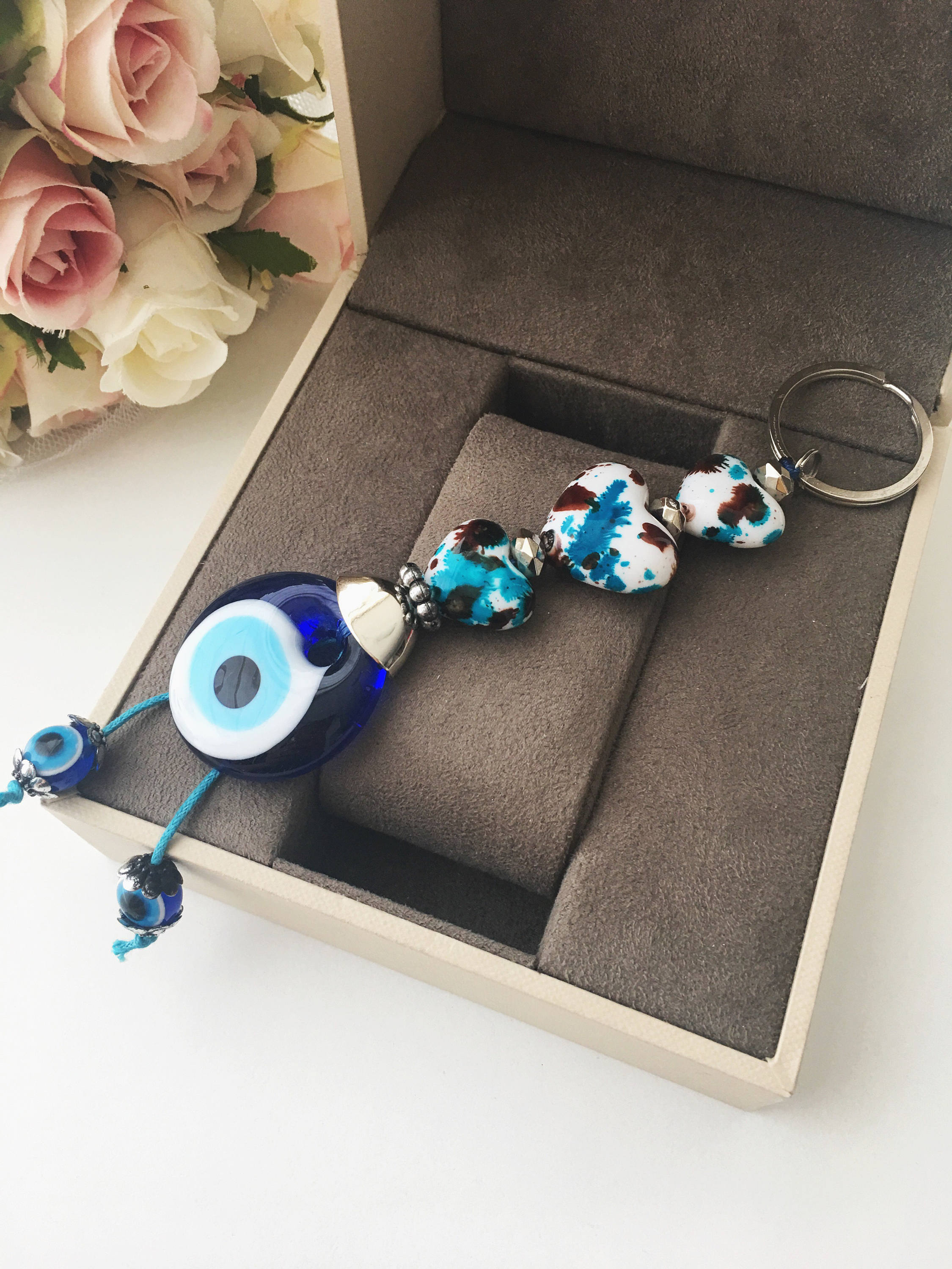 Evil eye key chain featuring a ceramic heart charm, symbolizing protection and good luck, perfect for keys or bags.