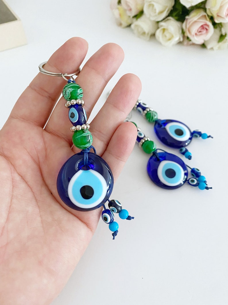 Evil Eye Keychain featuring green beads and a blue glass evil eye bead, symbolizing protection and good luck.