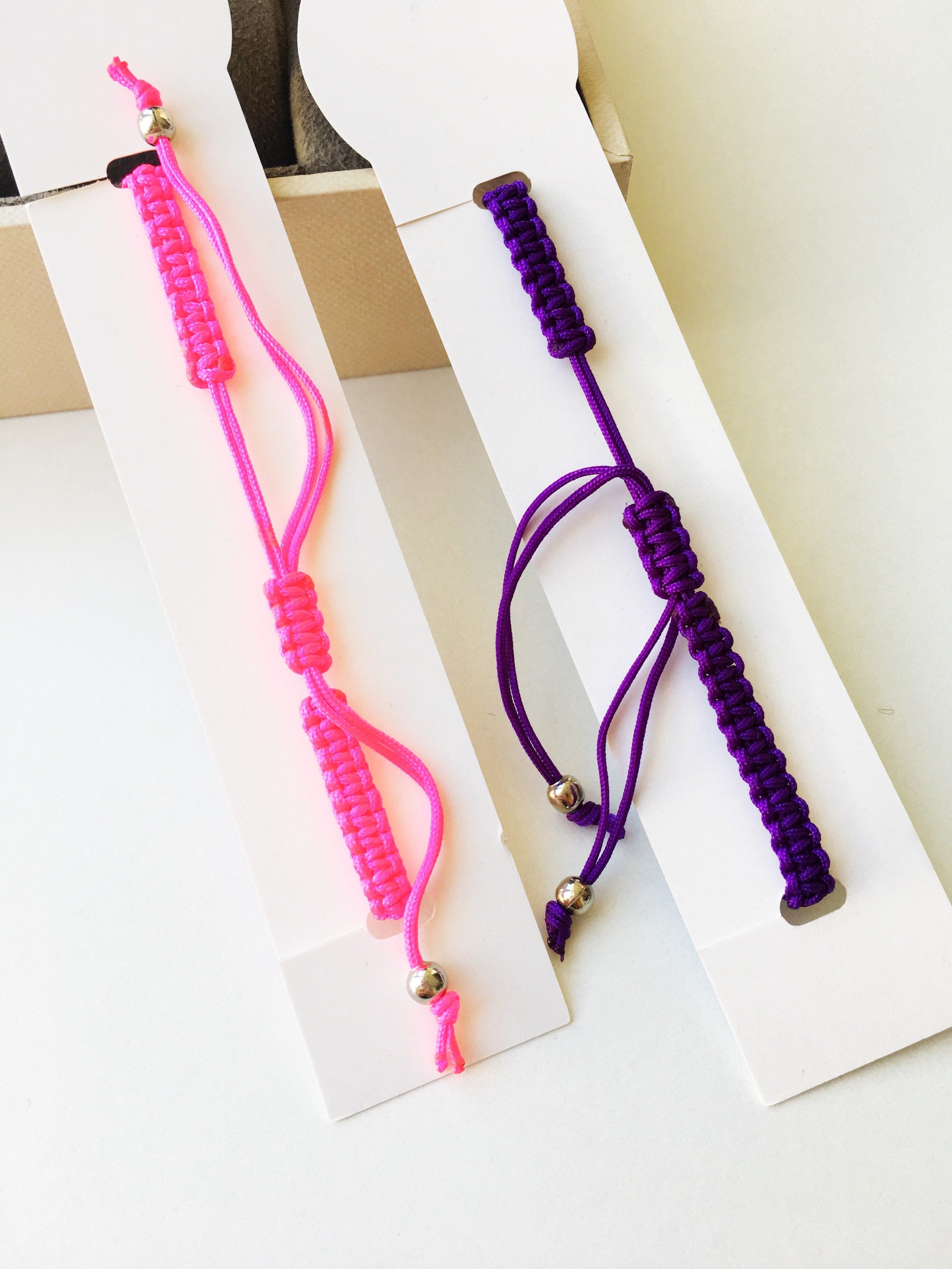 Evil Eye Macrame Bracelet featuring a black and white evil eye charm with colorful adjustable strings, handmade with intricate macrame design.