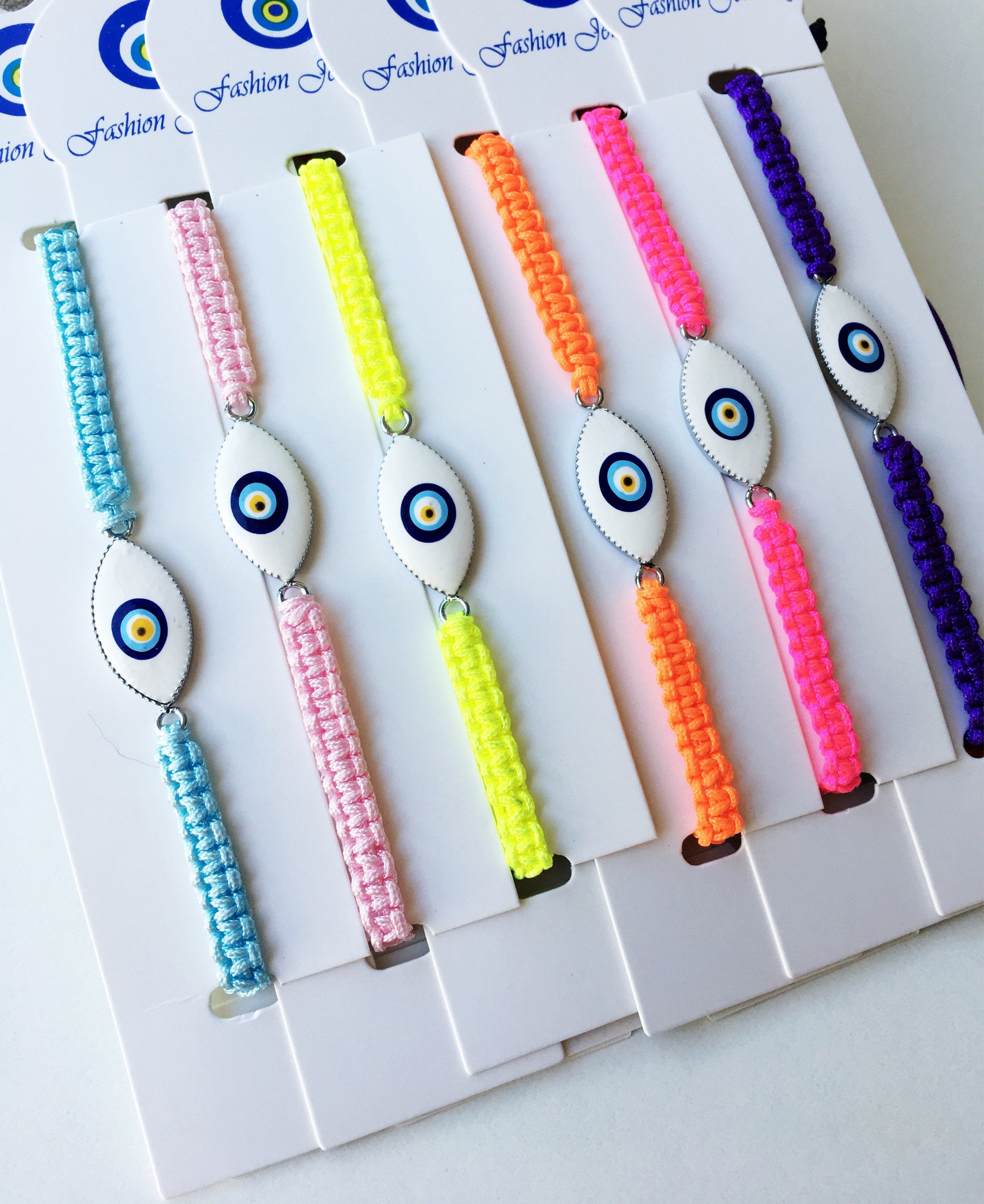 Evil Eye Macrame Bracelet featuring a black and white evil eye charm with colorful adjustable strings, handmade with intricate macrame design.