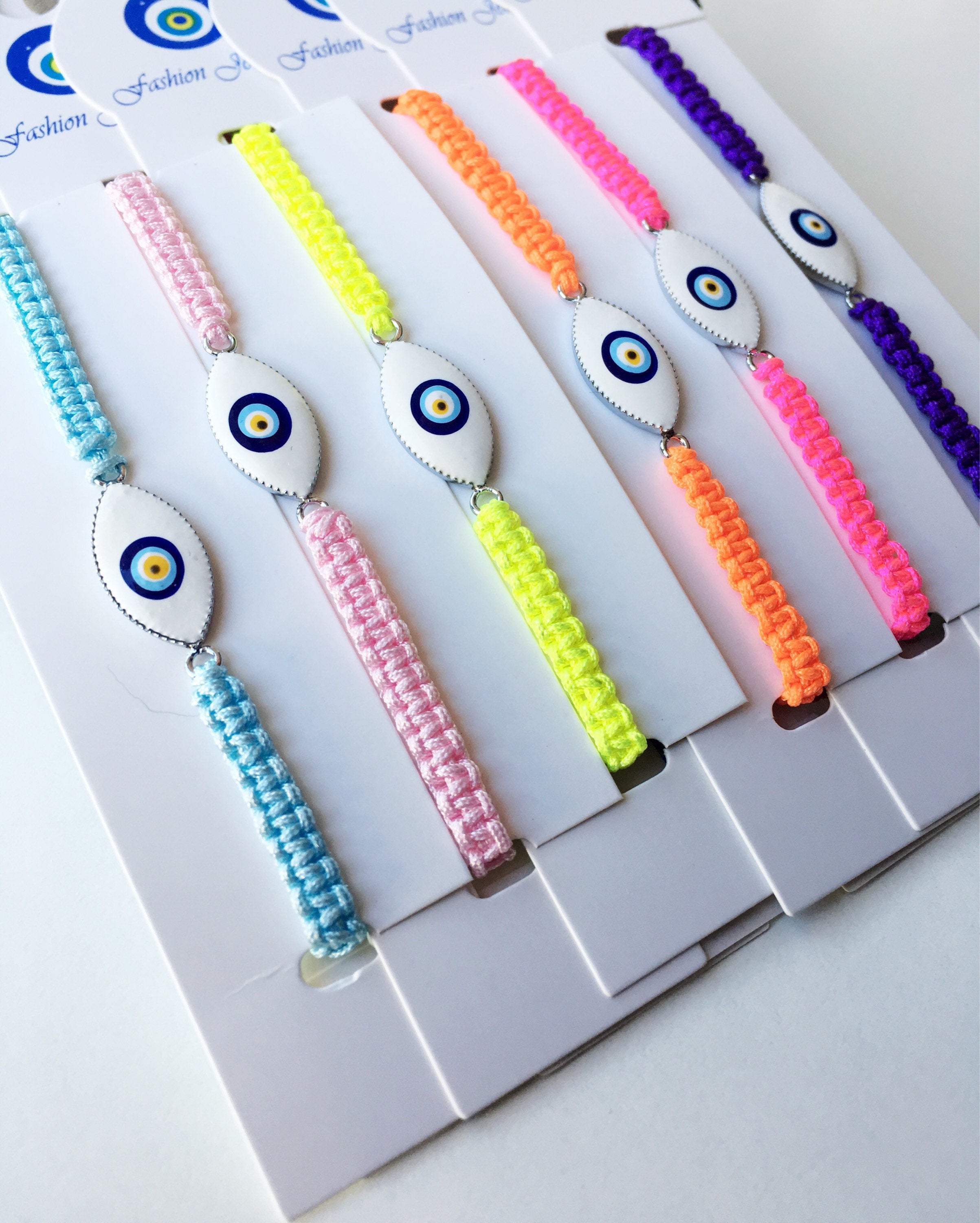 Evil Eye Macrame Bracelet featuring a black and white evil eye charm with colorful adjustable strings, handmade with intricate macrame design.