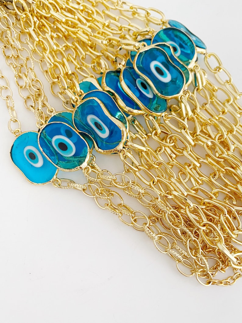 Evil Eye Murano Bracelet featuring handmade glass beads and a gold chain, showcasing a blue evil eye charm.