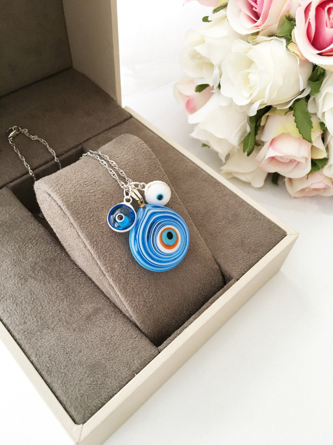 Handmade Evil Eye Murano Glass Necklace featuring a large blue evil eye bead and tiny white and turquoise beads, symbolizing protection.