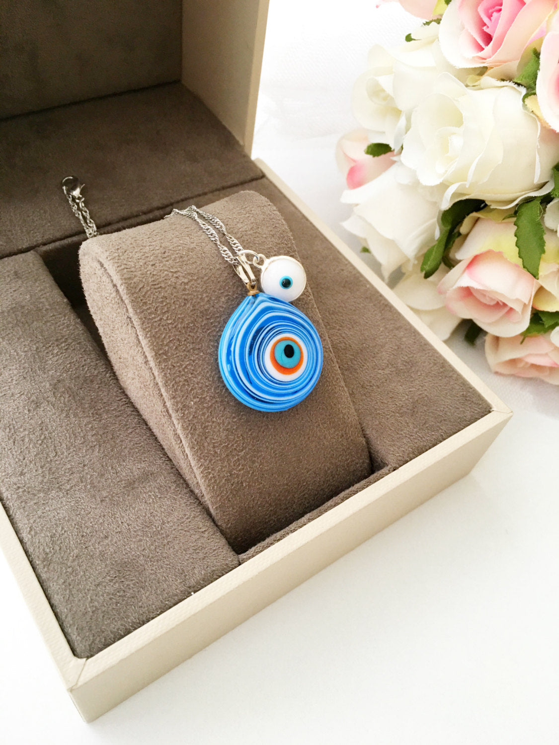 Handmade Evil Eye Murano Glass Necklace featuring a large blue evil eye bead and tiny white and turquoise beads, symbolizing protection.