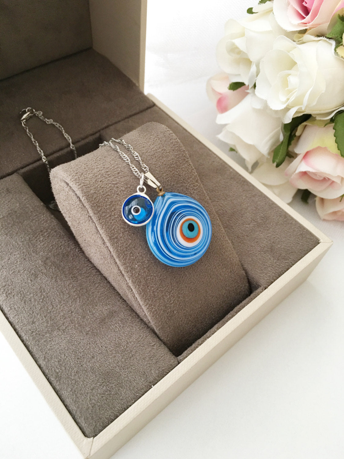 Handmade Evil Eye Murano Glass Necklace featuring a large blue evil eye bead and tiny white and turquoise beads, symbolizing protection.