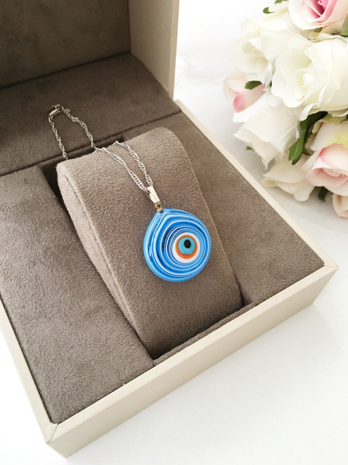 Handmade Evil Eye Murano Glass Necklace featuring a large blue evil eye bead and tiny white and turquoise beads, symbolizing protection.