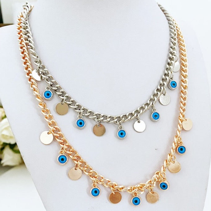Handmade Evil Eye Necklace featuring a curb Cuban chain in silver and gold with tiny glass evil eye beads and gold-plated charms.