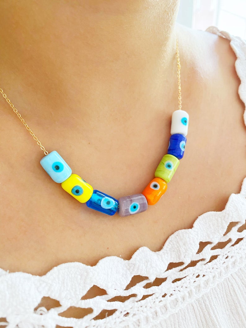 A beautifully handcrafted Evil Eye Necklace featuring colorful Murano tube beads and a stainless steel chain in gold or silver.